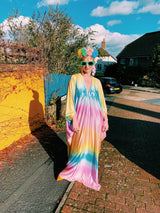 Model wearing a shimmering, liquid holographic maxi kaftan dress in pastel rainbow colors.