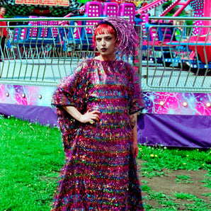 Model wearing the TINSEL Maxi Black and Multicoloured Shimmer kaftan Dress at the funfair