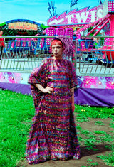 Model wearing the TINSEL Maxi Black and Multicoloured Shimmer kaftan Dress at the funfair