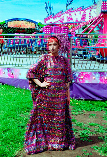 Model wearing the TINSEL Maxi Black and Multicoloured Shimmer kaftan Dress at the funfair