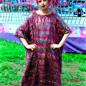 Model wearing the TINSEL Maxi Black and Multicoloured Shimmer kaftan Dress at the funfair