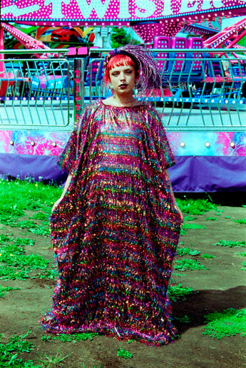 Model wearing the TINSEL Maxi Black and Multicoloured Shimmer kaftan Dress at the funfair