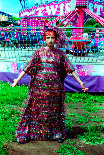 Model wearing the TINSEL Maxi Black and Multicoloured Shimmer kaftan Dress at the funfair