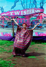 Model wearing the TINSEL Maxi Black and Multicoloured Shimmer kaftan Dress at the funfair