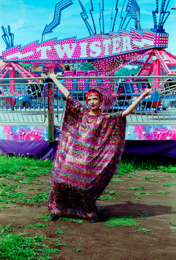 Model wearing the TINSEL Maxi Black and Multicoloured Shimmer kaftan Dress at the funfair